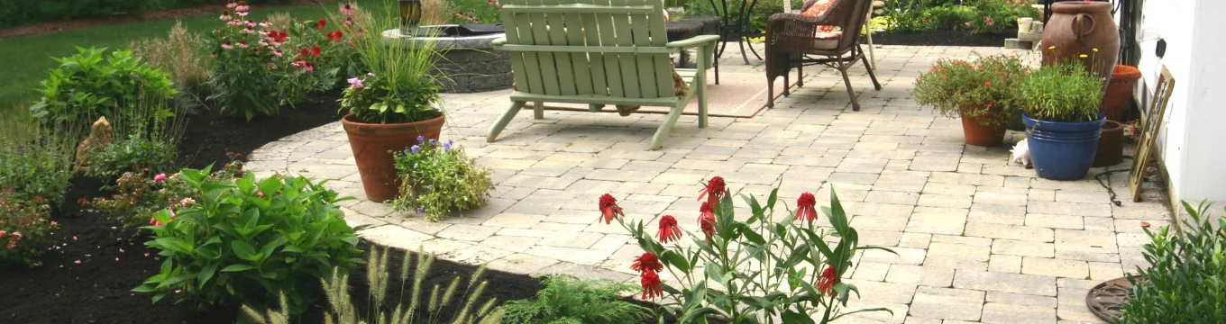 Landscape installation with planting beds around a paver patio in Connecticut